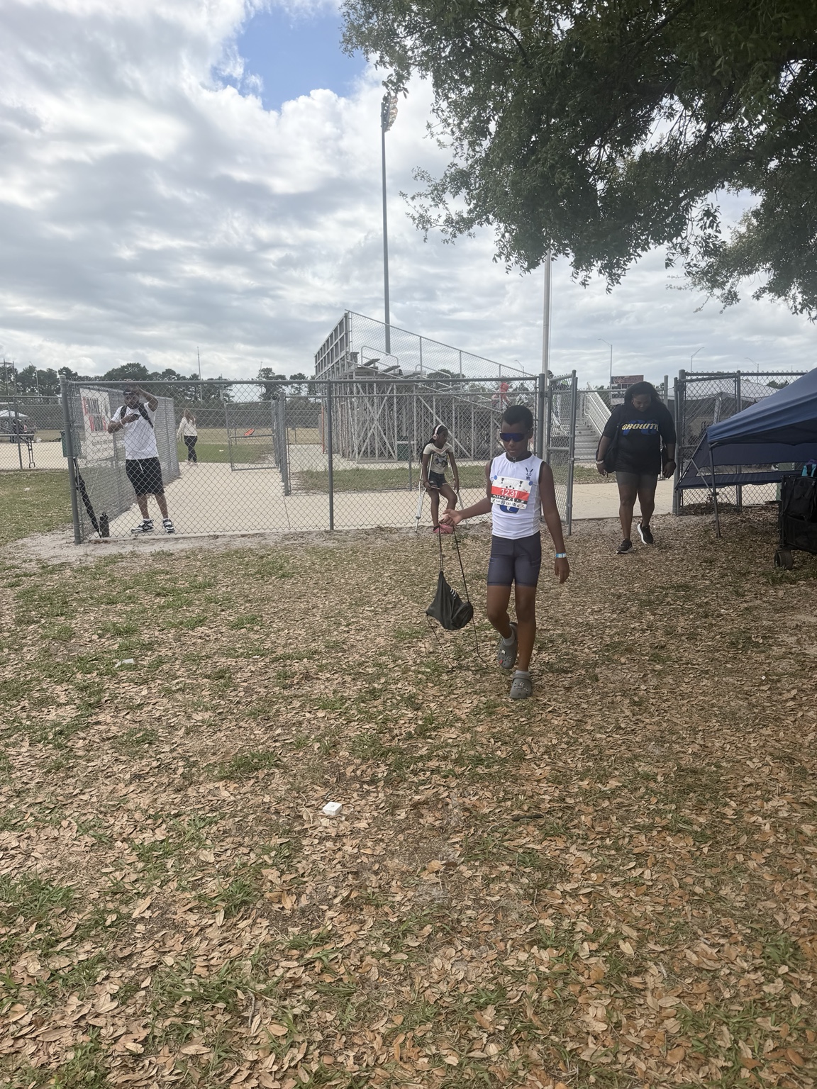 Athlete in white team uniform walking after a track competition