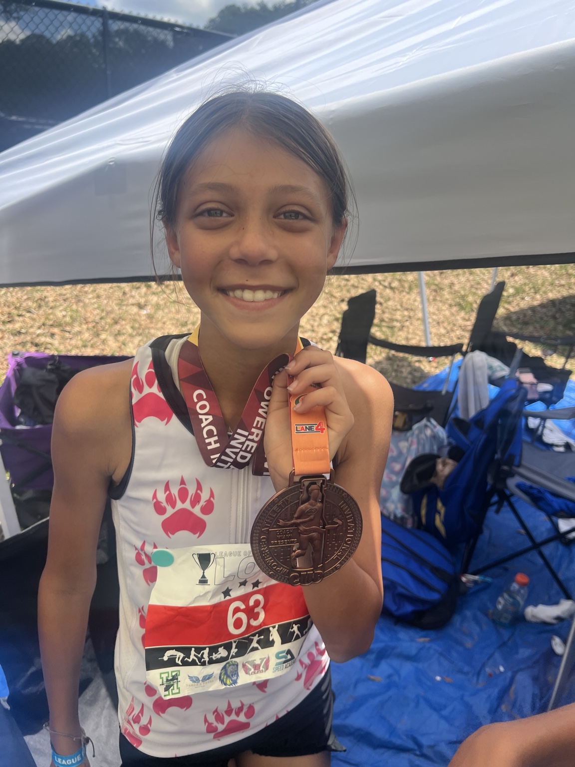 Young athlete smiling and holding a bronze medal