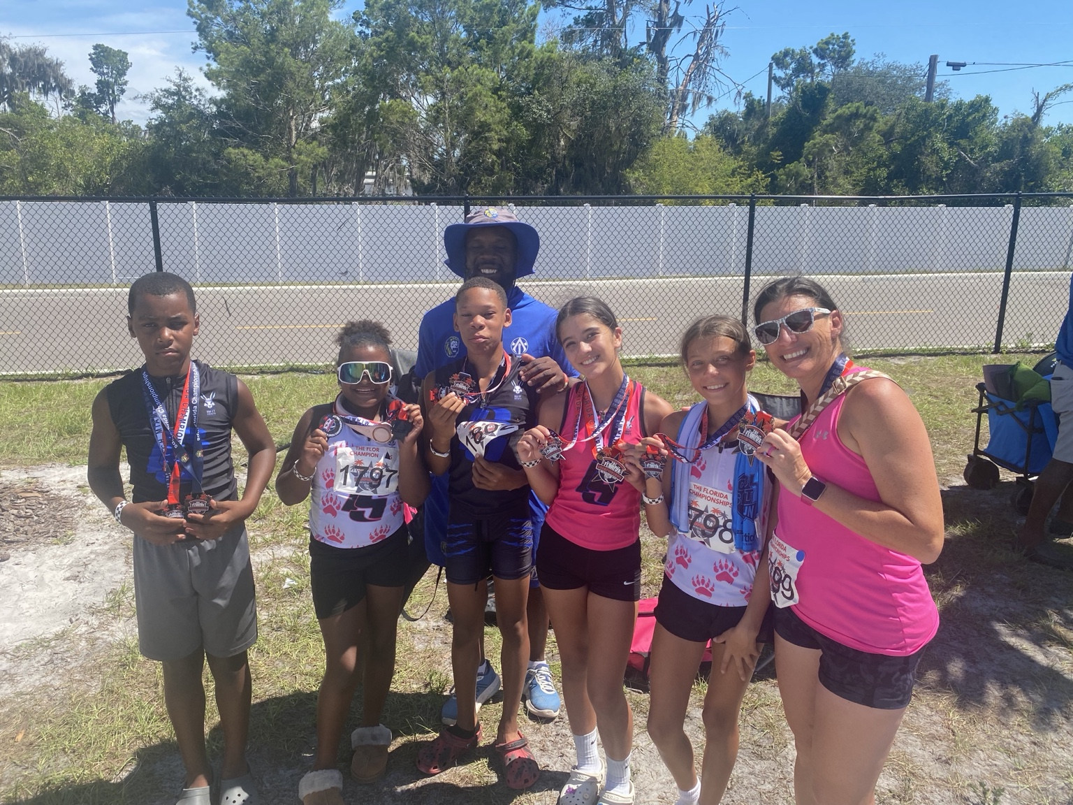Athletes and coaches celebrating their track medals