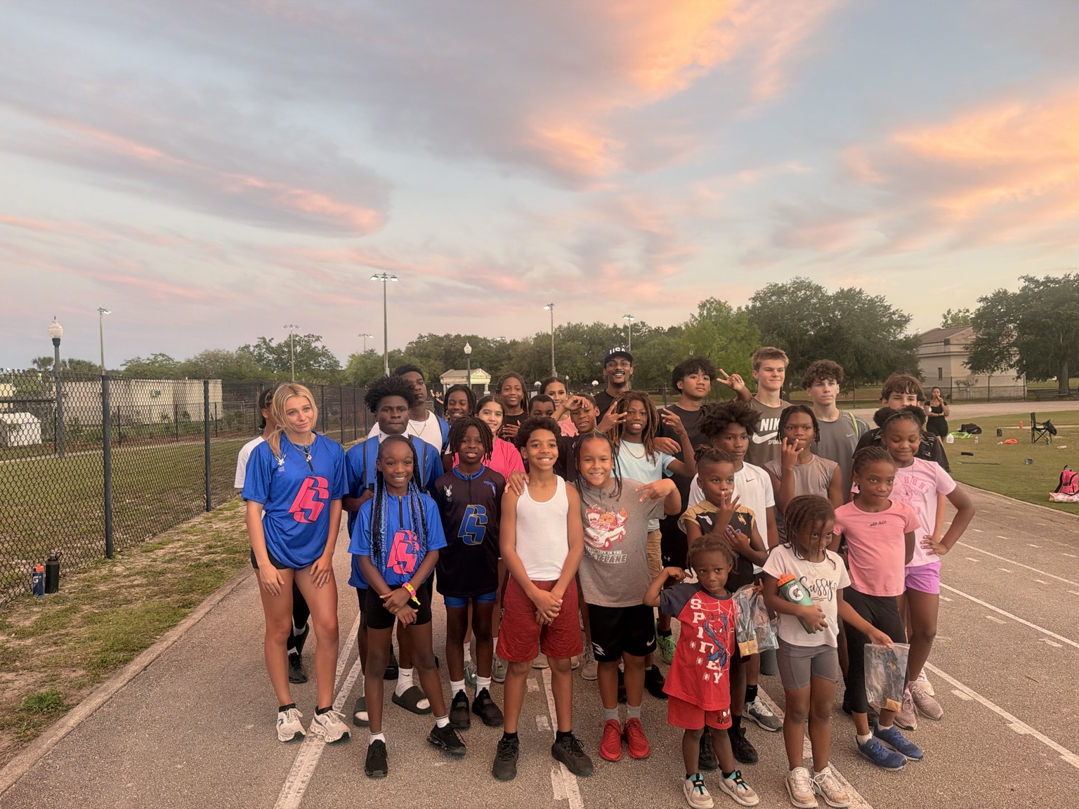 FS NextGen team athletes and coaches together on a track at sunset