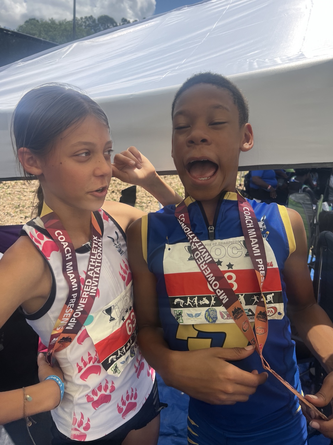 Two athletes sharing a candid moment with medals